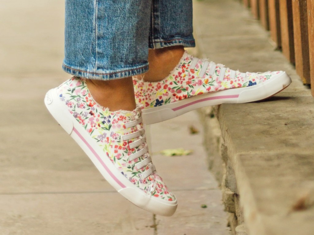 woman wearing white floral print sneakers