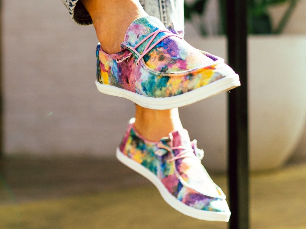 person wearing tie dye slip on sneakers