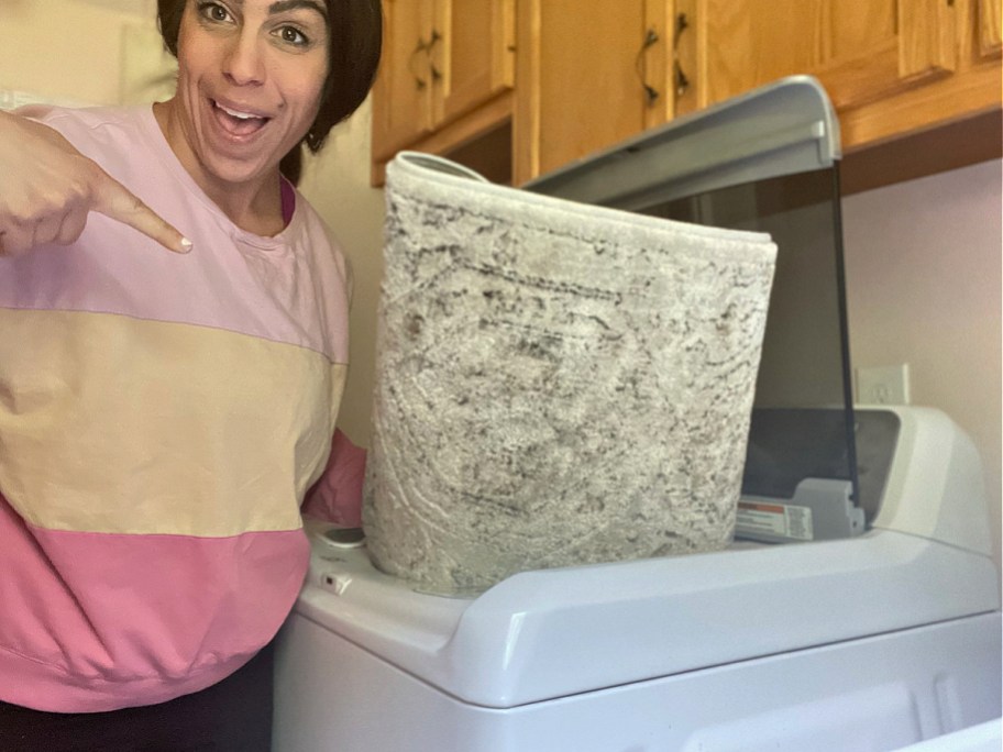 woman putting rug into washing machine