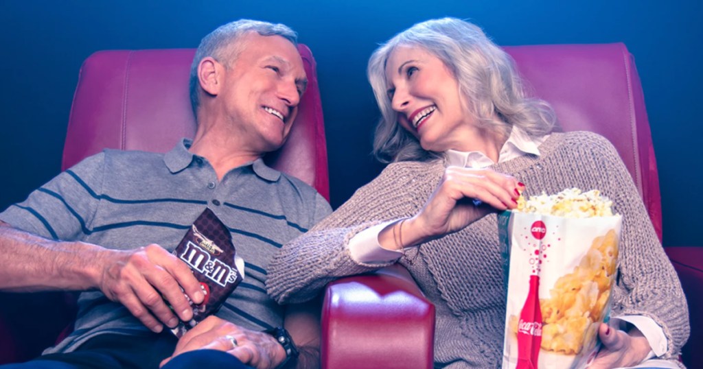 older man and woman watching movie in theatre
