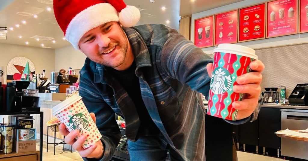 man in santa hat holding Starbucks cups