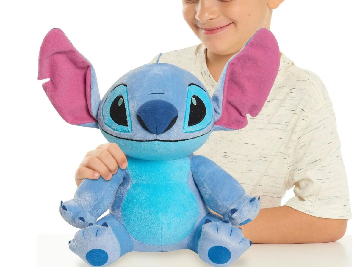 A child holding a Stitch plush doll