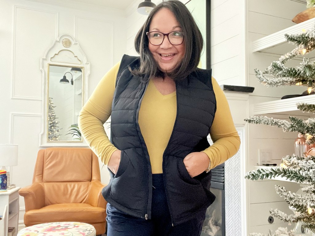 woman wearing yellow long sleeve top with black vest