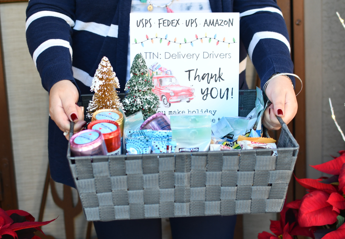 Woman holding a gift basket for her delivery driver with a free thank you printable inside