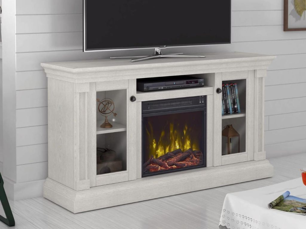 Fireplace TV stand with a TV on top and a fire in the fireplace