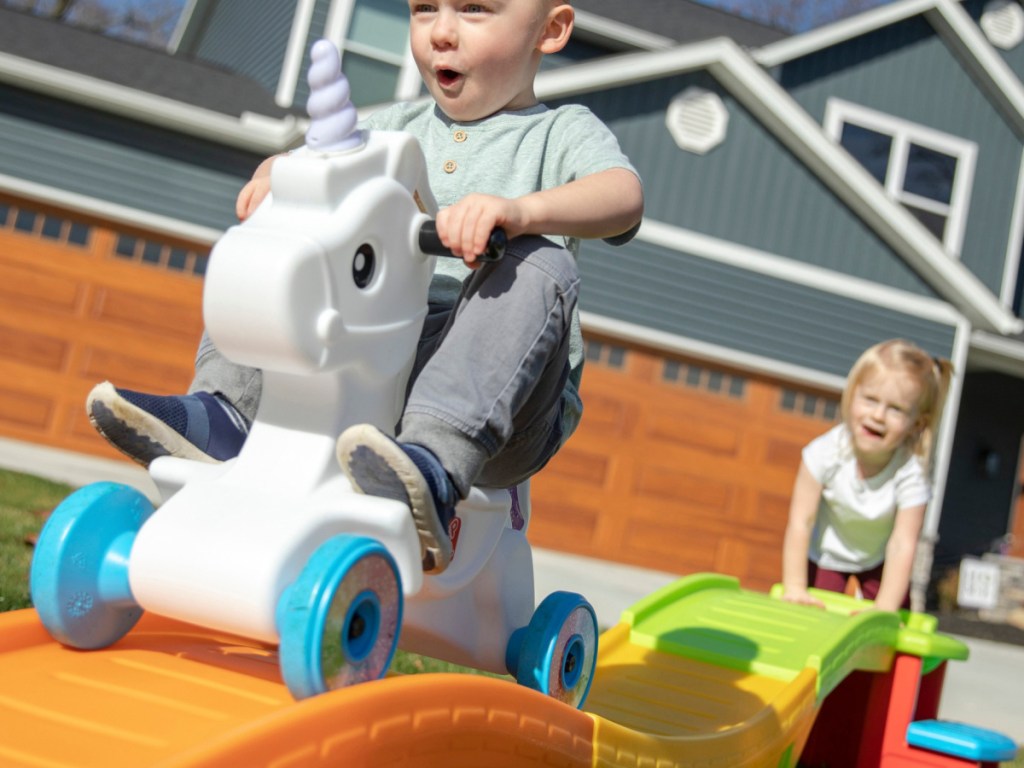 little boy riding unicorn coaster and smiling