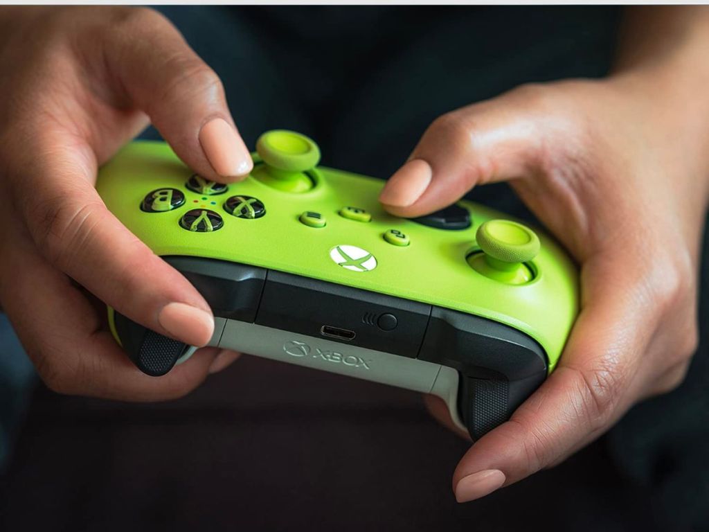 a mans hands shown using an Xbox Core Wireless Controller in Electric Volt