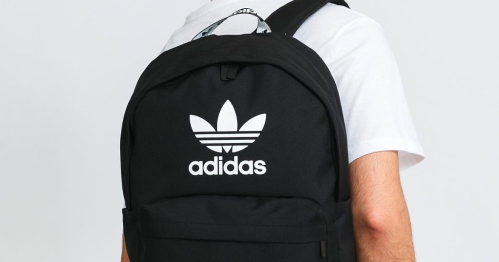 man wearing black adidas backpack on back