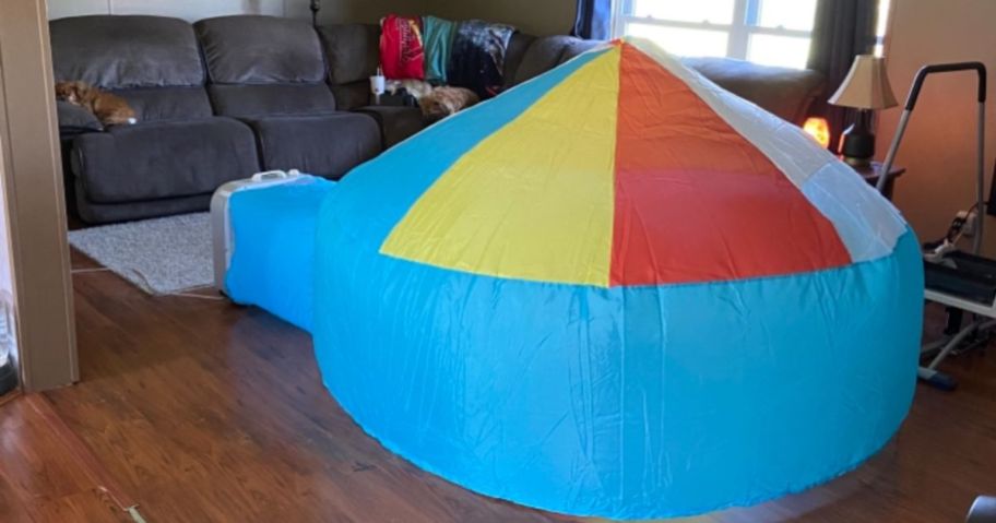 blue Airfort Inflatable Play Tent with red, yellow, white top shown blown up in living room