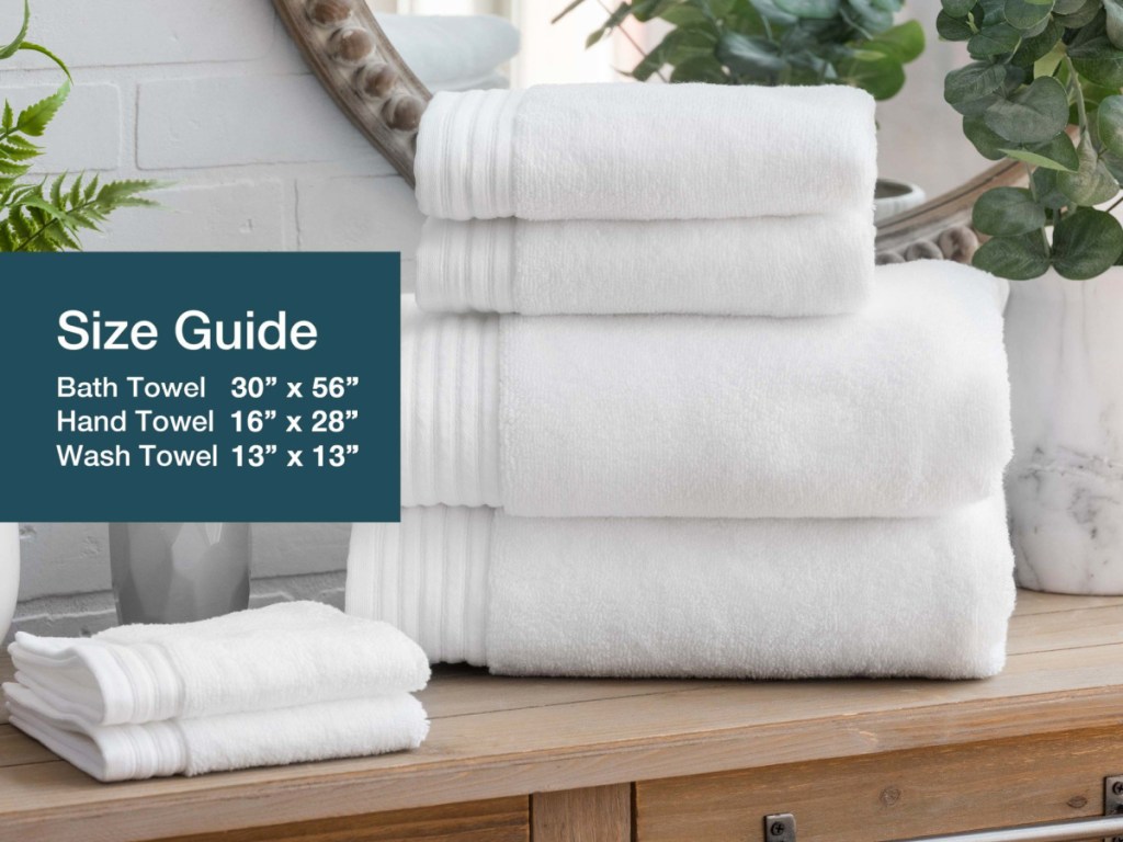 a stack of egyptian cotton towels and hand towels stacked in a bathroom