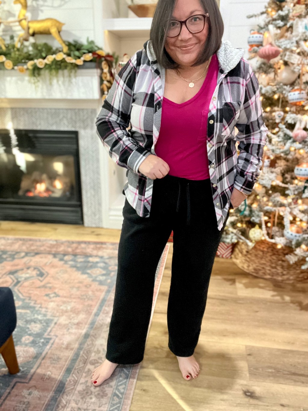 woman wearing black sweatpants standing in front of christmas tree