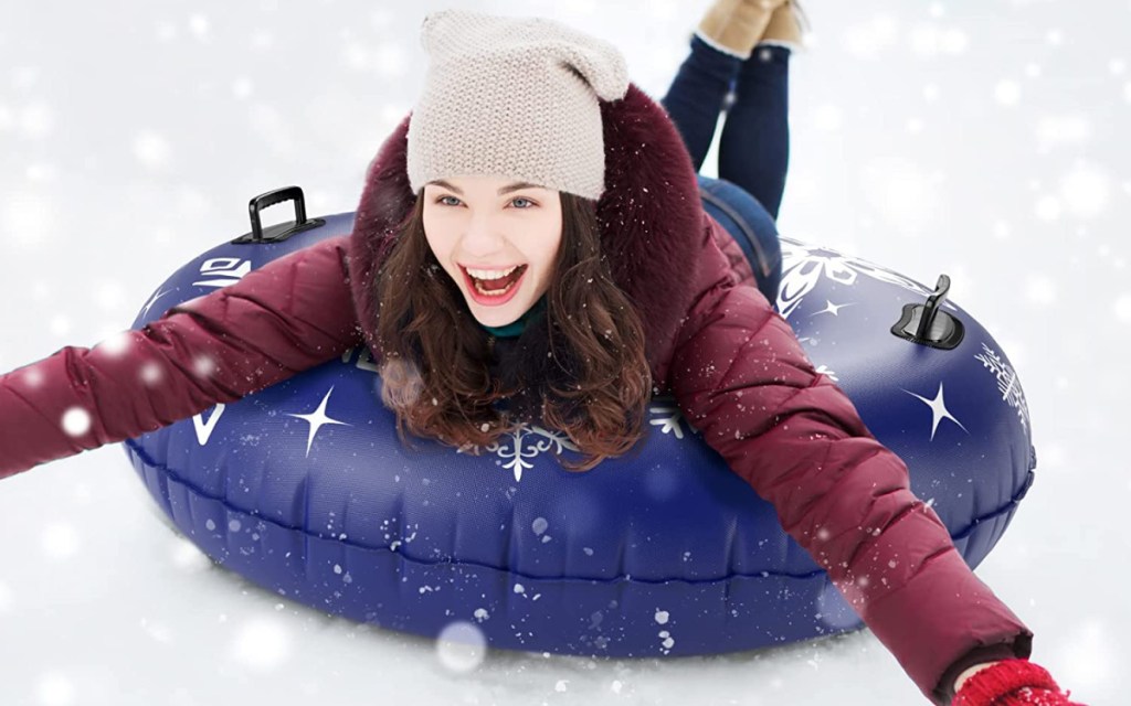 woman laying down on snow tube