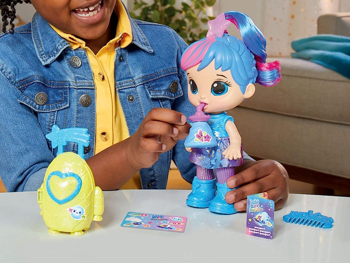 girl playing with baby alive doll with blue and pink hair