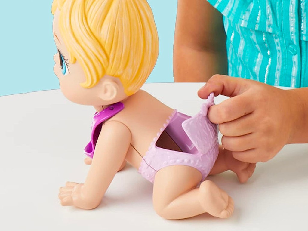 child opening diaper flap on baby alive doll