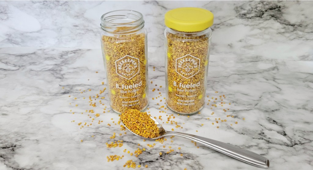 two jars of bee pollen next to spoon