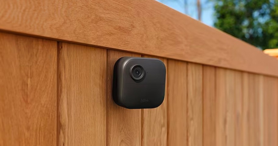 black blink camera on wooden fence