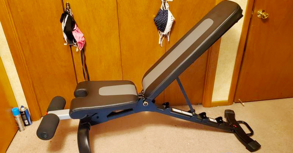 bowflex weight bench in front of doors with cloth masks hanging behind it
