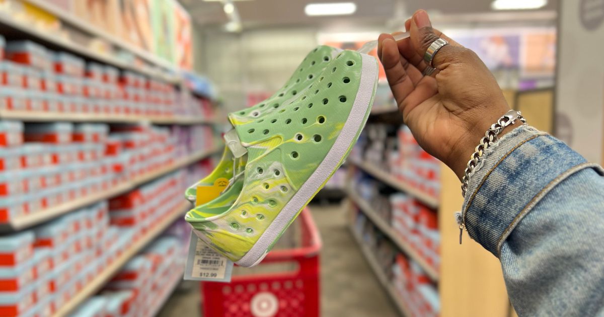 hand holding pull on green and yellow water shoes in store