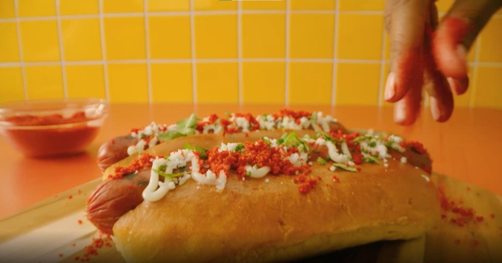 topping hot dogs with Cheetos dust