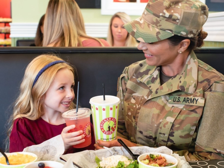 child eating with woman in military uniform