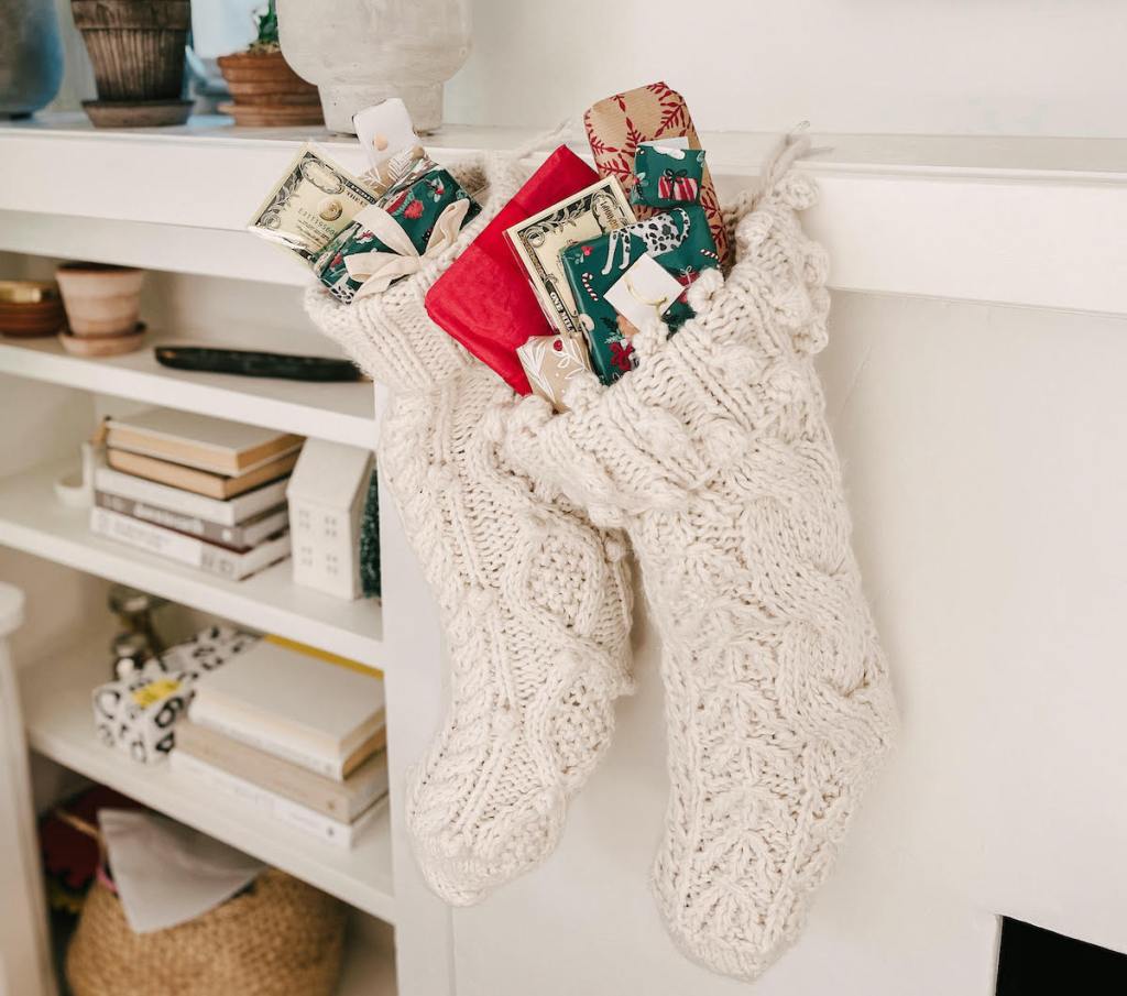 two white knit christmas stocking on mantle 