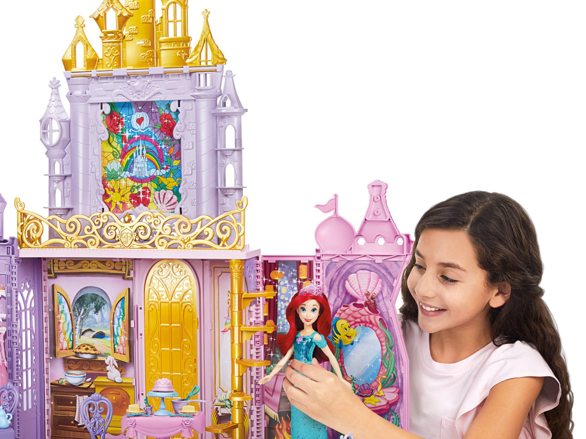 stock image of a girl playing with the disney princess fold n go celebration castle