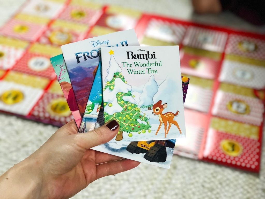 holding mini books from the Disney Storybook collection