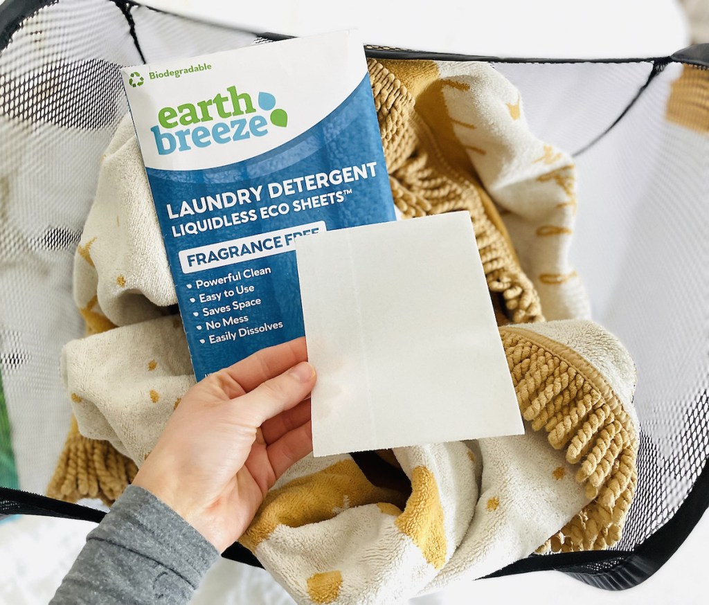 hand holding earth breeze natural laundry detergent sheets