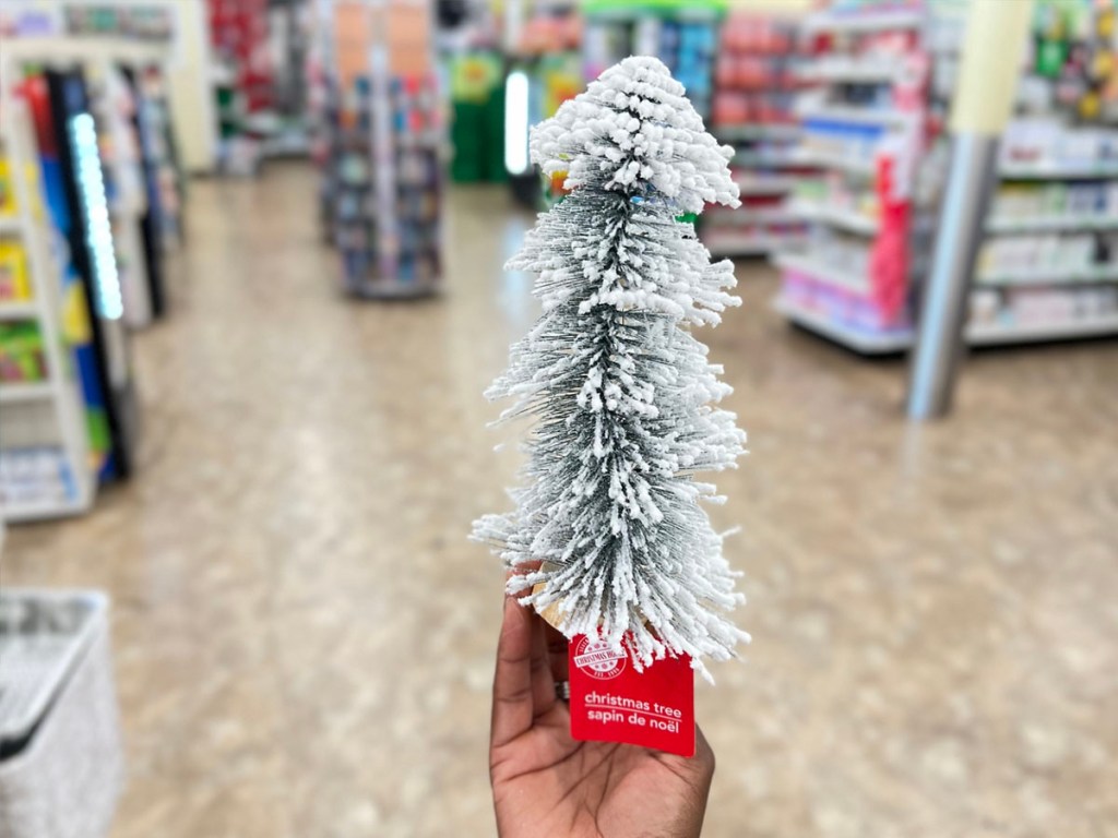 يد تحمل شجرة عيد الميلاد الصغيرة المتدفقة