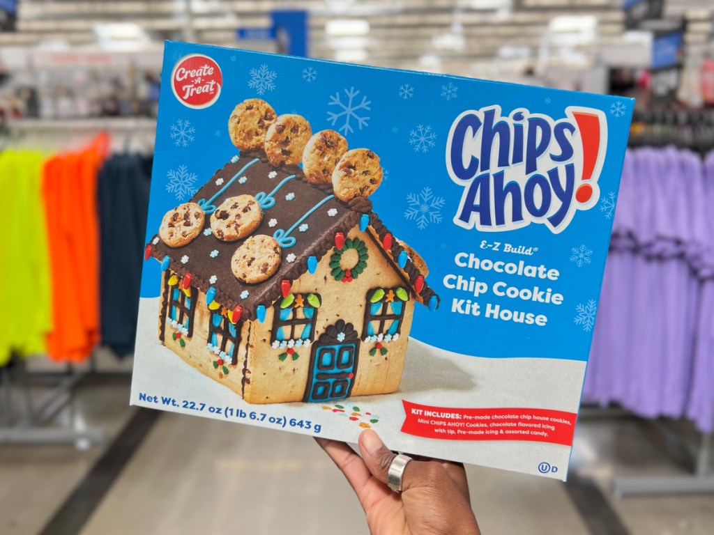 hand holding chocolate chip cookie gingerbread house kit 