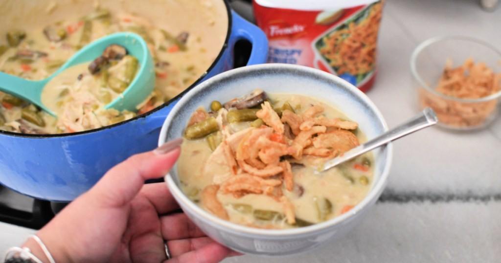 holding a bowl of green bean casserole soup