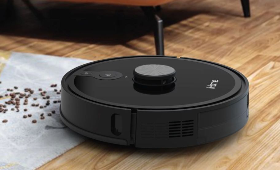 a black robot vacuum cleaning up a spill