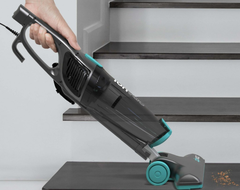 woman vacuuming stairs with an ionvac stick vac