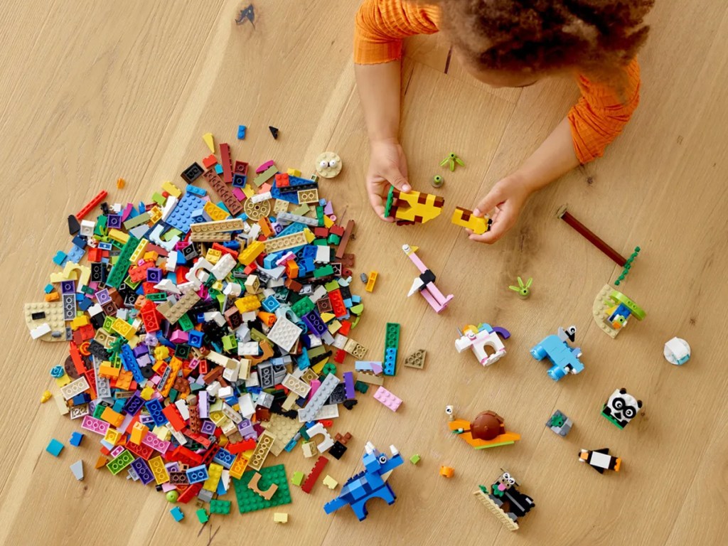 girl playing with lego animal brick set