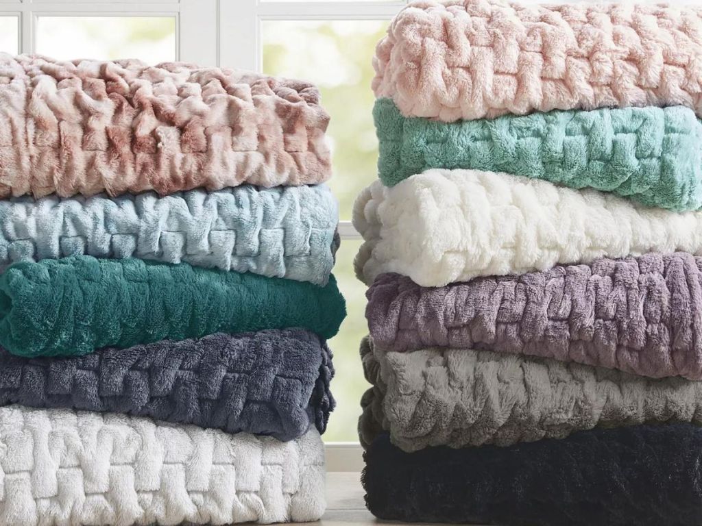 faux throws stacked in two piles