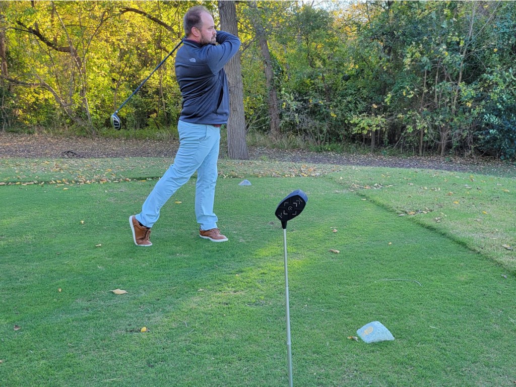 man golfing with golf speaker in front of him