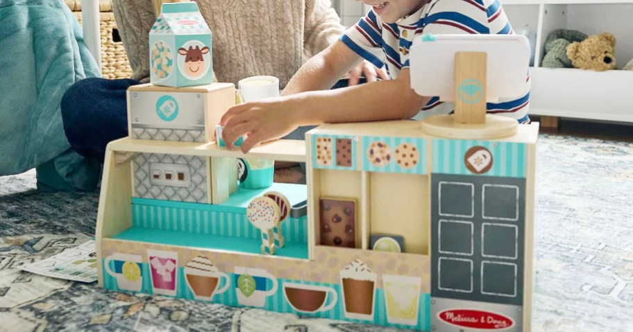 kid playing with wood barista set