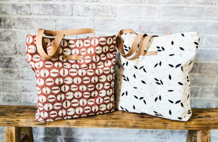 two minted canvas tote bags on wood bench