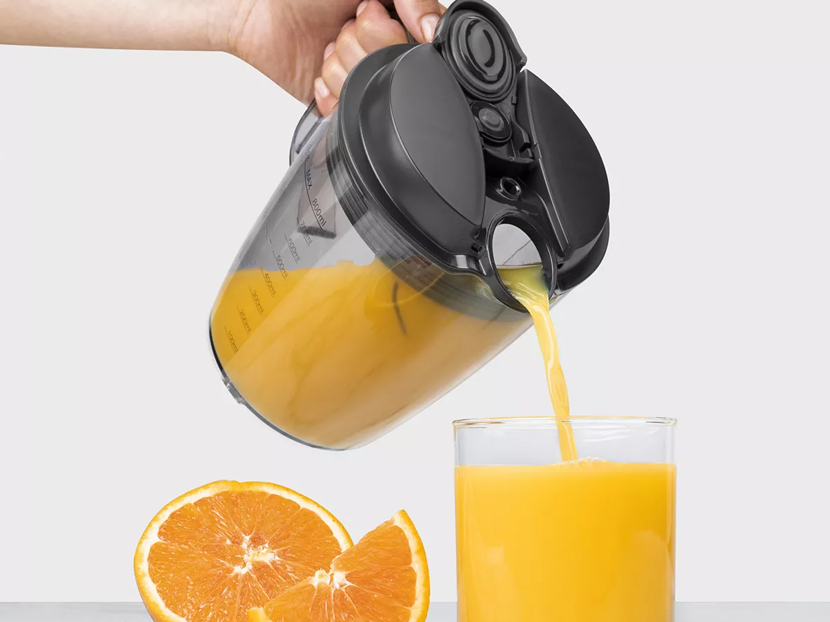 hand pouring juice into cup from NutriBullet Juicer