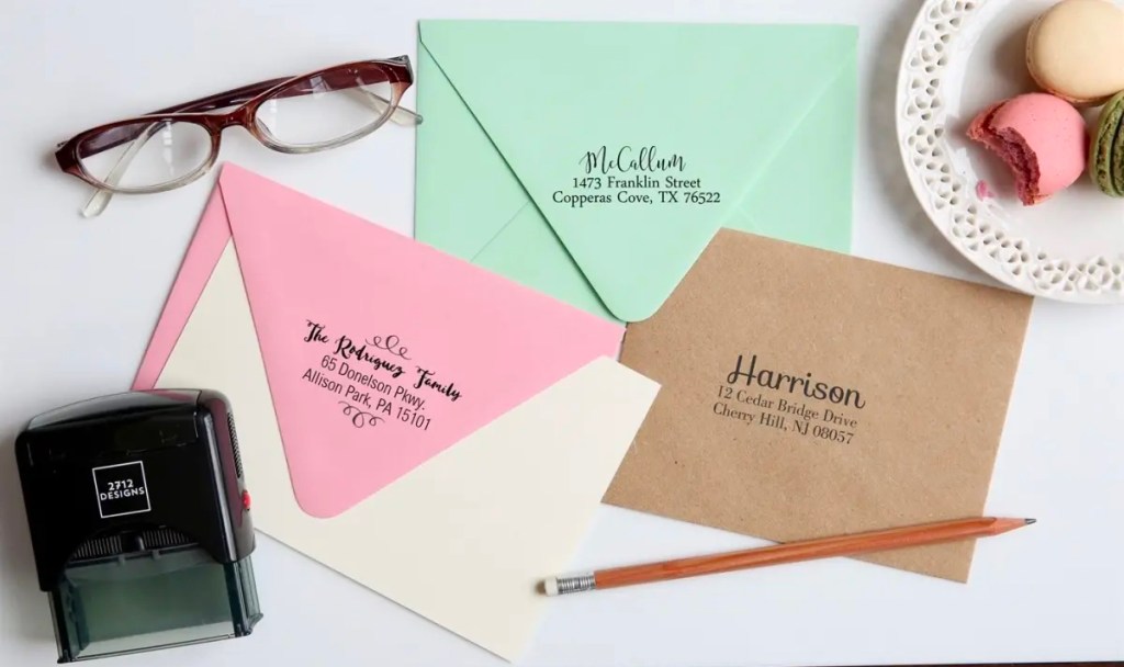 personalized stamper with three envelopes and glasses on table
