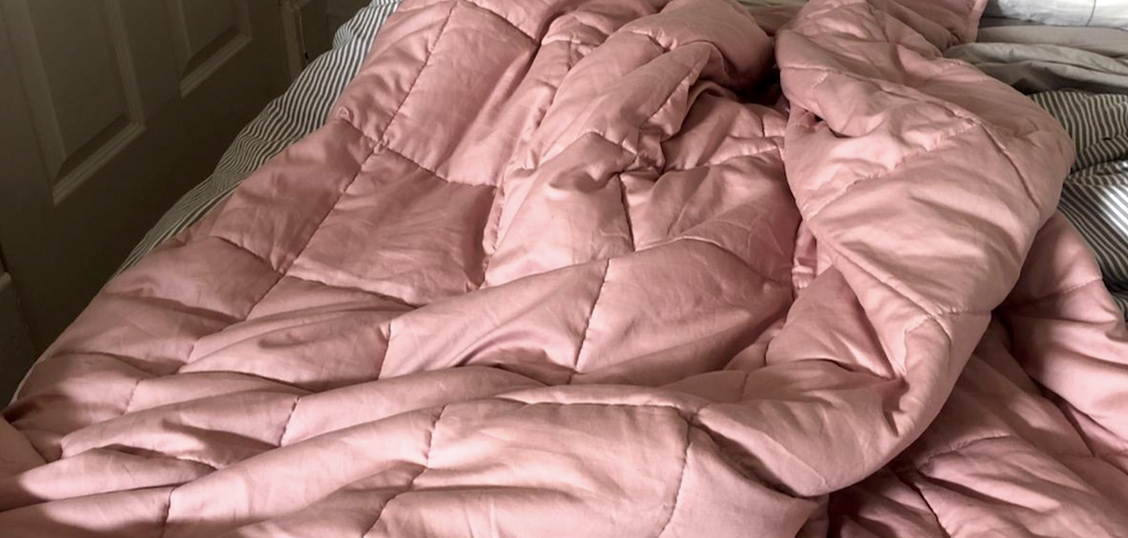 pink weighted blanket on bed