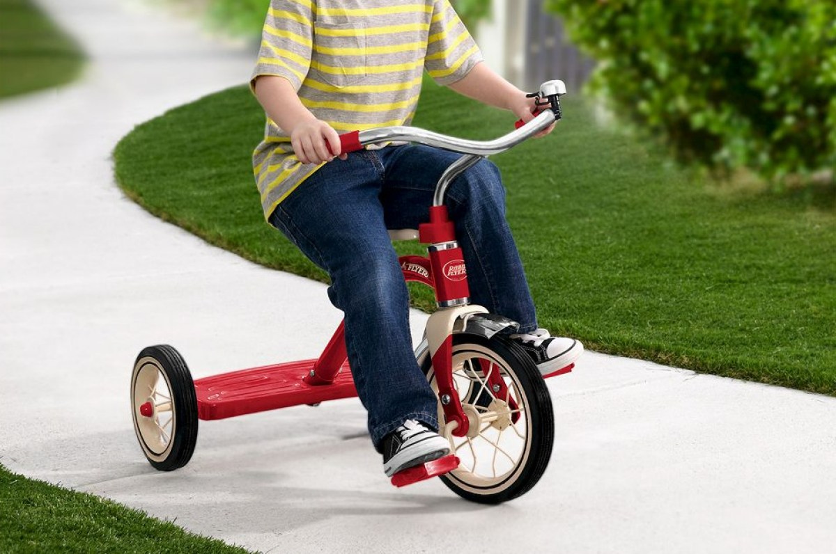 child riding on a radio flyer tricycle