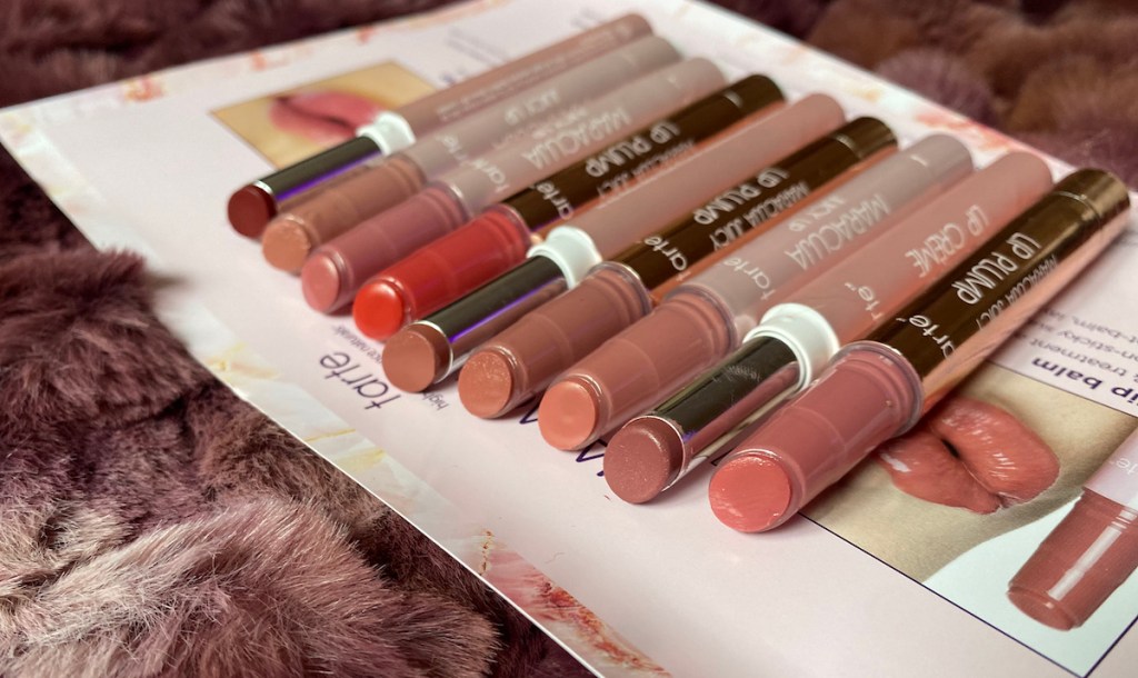various shades of tarte lip products in a row on purple faux fur blanket