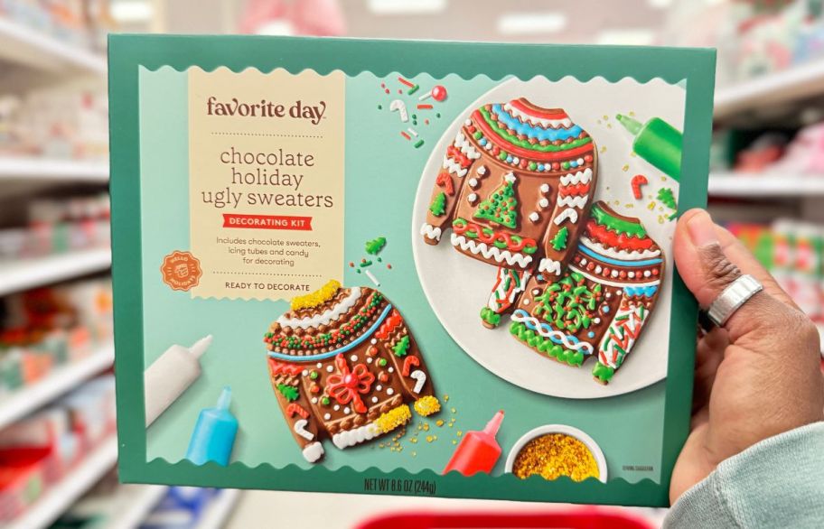 a womans hand holding a sugar cookie decorating kit