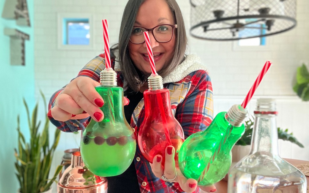 woman holding bulb cups with straws and cocktails inside