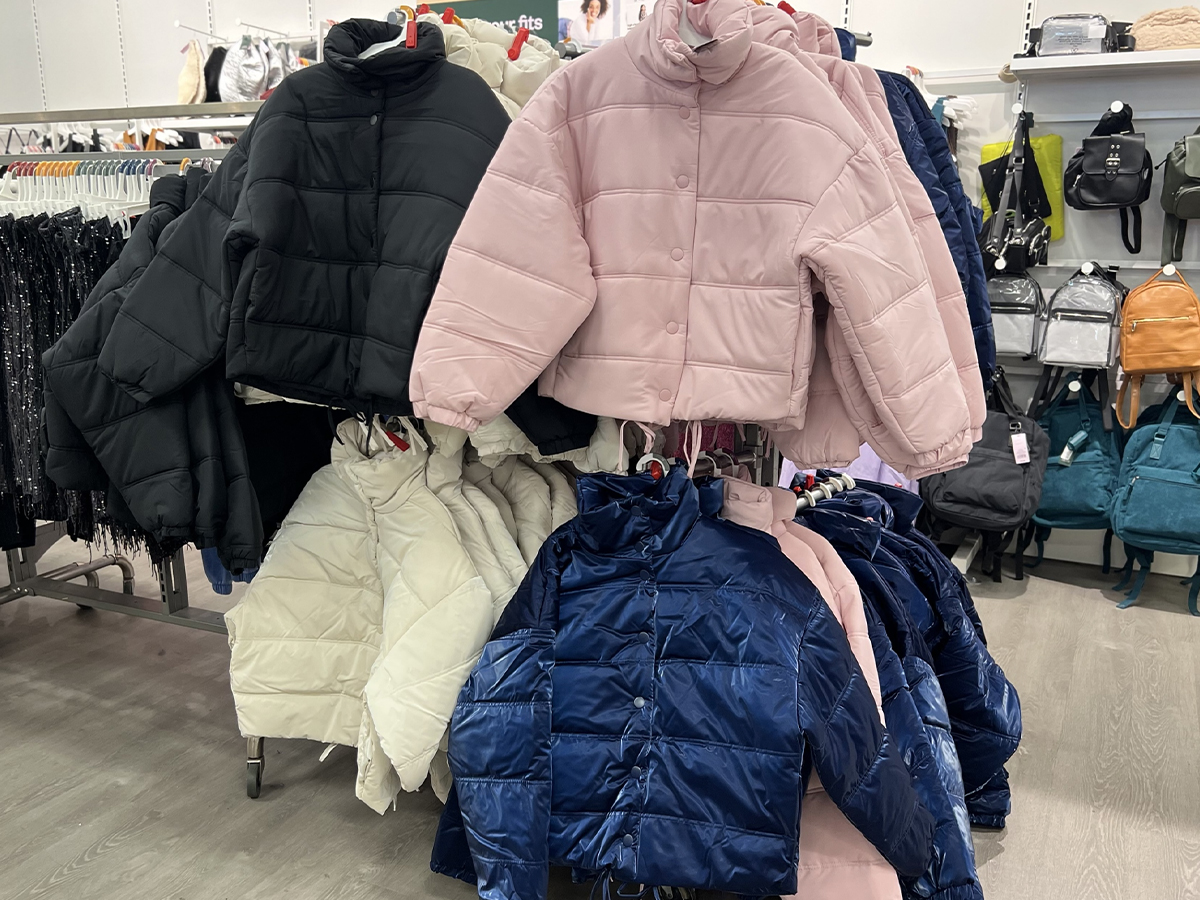 black, pink, white and blue puffer jackets hanging in target store