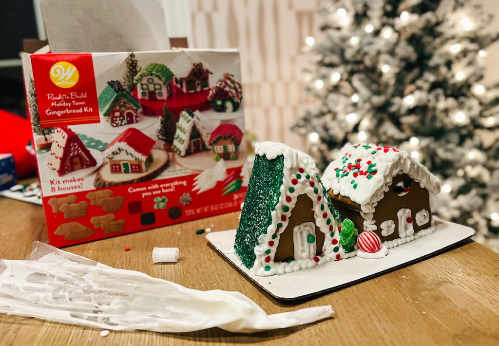 wilton gingerbread house kit with two decorated houses on table