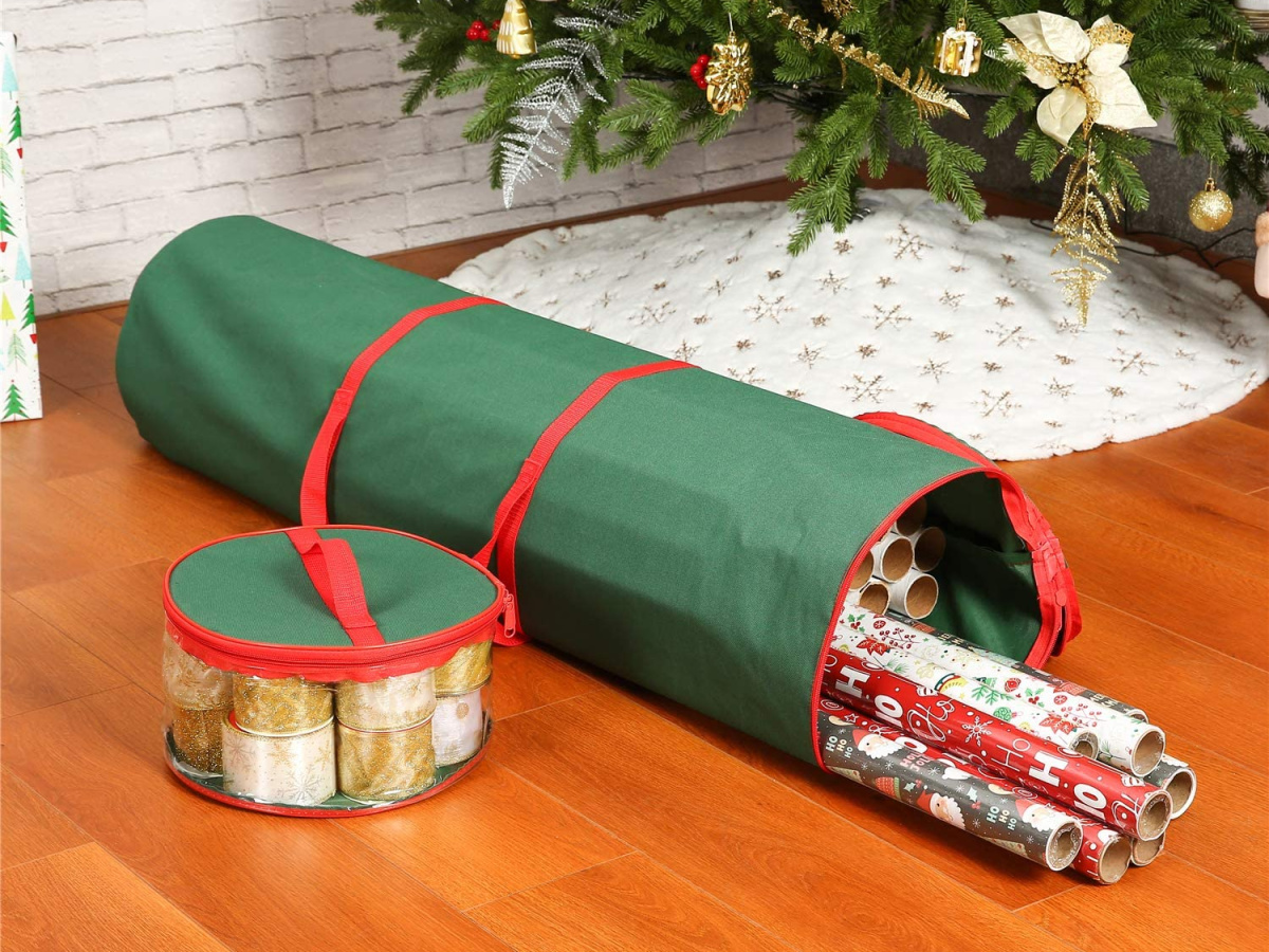 wrapping paper storage bag filled with rolls of paper and a container of ribbon next to it