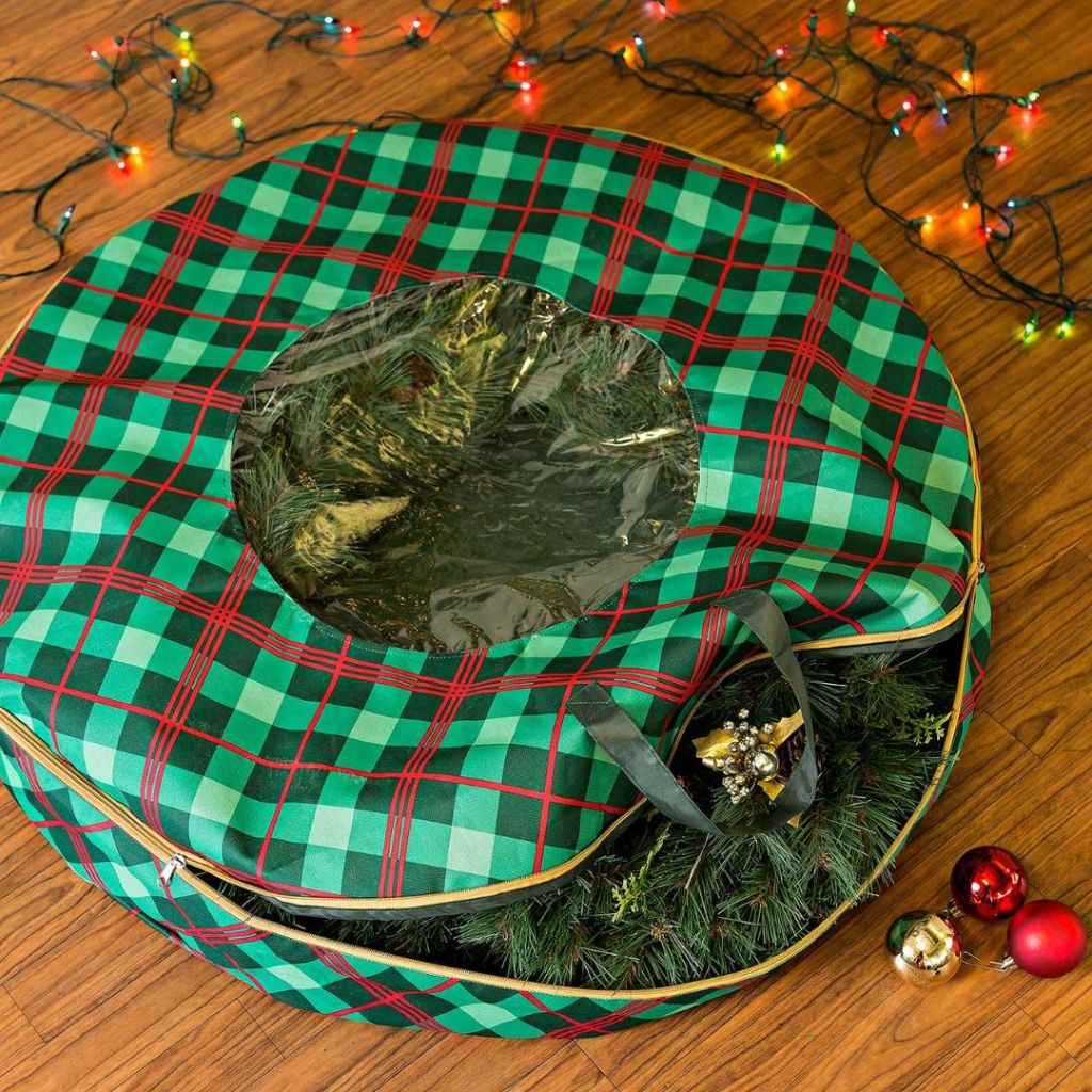 Honey-Can-Do Plaid 36-inch Wreath Storage Bag shown with wreath inside and ornaments laying around it