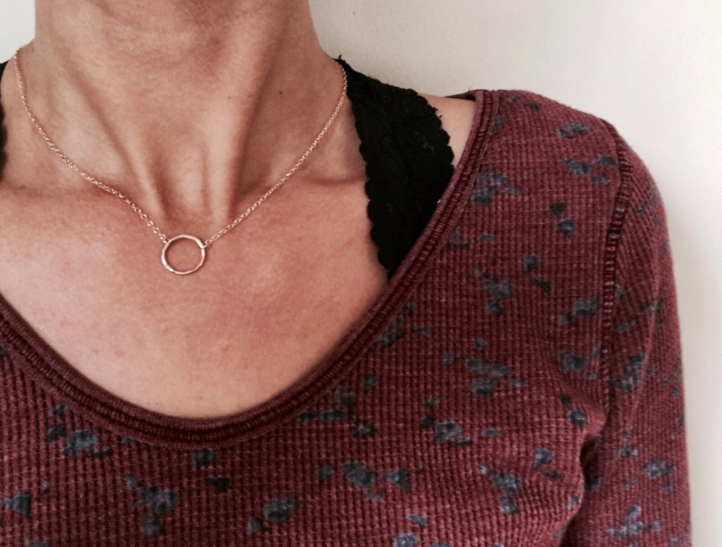 close up of women wearing rose gold circle necklace